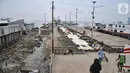 Warga melintasi bekas lokasi warung makan pasca direlokasi di Pelabuhan Kali Adem, Muara Angke, Jakarta Utara, Senin (13/6/2022). Relokasi pedagang sebagai upaya menata kawasan pelabuhan serta menghindari banjir ROB yang kerap terjadi. (merdeka.com/Iqbal S Nugroho)