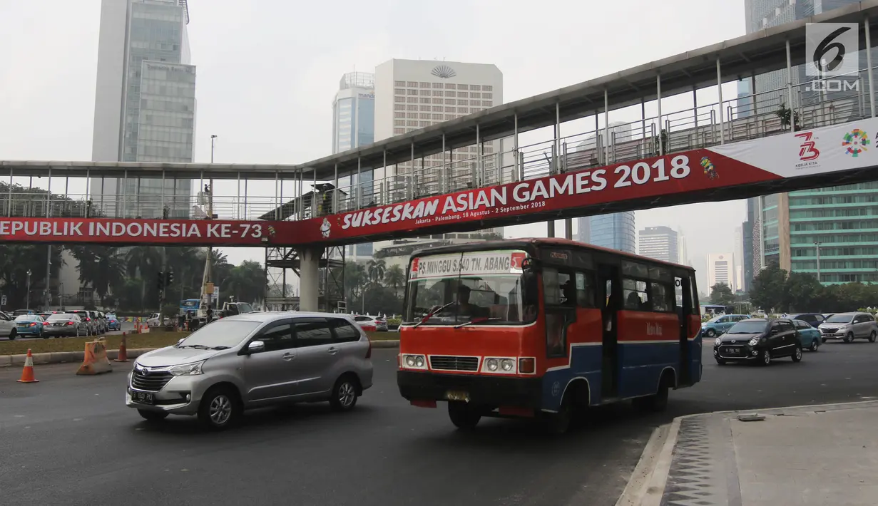 Pengendara melintas melintas di bawah jembatan penyeberangan orang (JPO) di Bundaran HI, Jakarta, Selasa (24/7). Pemprov DKI berencana merobohkan JPO tersebut karena menghalangi pandangan ke Patung Selamat Datang. (Liputan6.com/Arya Manggala)