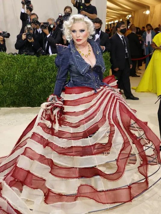Debbie Harry tiba di Met Gala 2021 mengenakan gaun rancangan Zac Posen. Gaun ini memiliki 3 warna khas bendera Amerika Serikat, yaitu atasan denim biru, dan rok organza berwarna merah-putih. Foto: Instagram @blondieofficial.