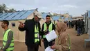 Pemilu ini digelar di tengah ketegangan yang tinggi dan kekhawatiran atas aneksasi wilayah oleh Israel. Tampak dalam foto, petugas pemilu Palestina menyiapkan Tempat Pemungutan Suara (TPS) darurat di tenda-tenda untuk pemilihan kota di Deir el-Balah, Jalur Gaza, pada Sabtu 25 April 2026. (Eyad Baba/AFP)