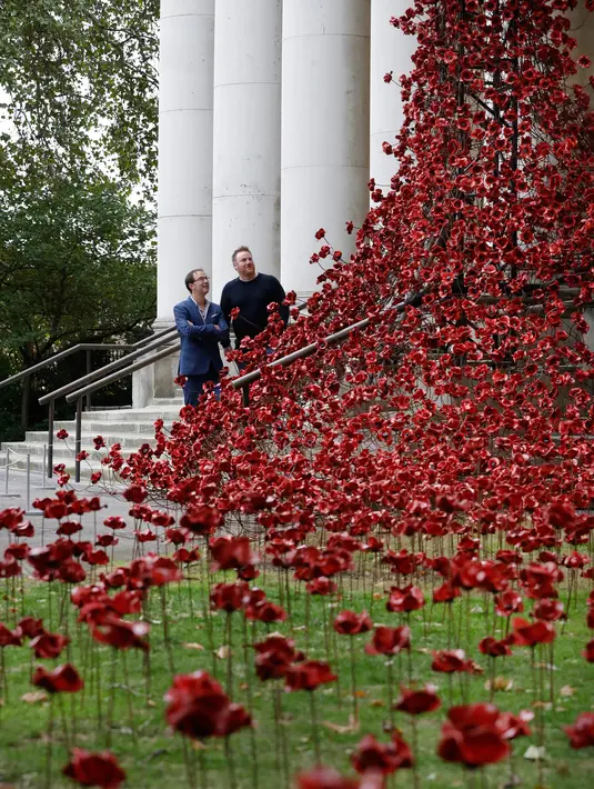 Pajangan karya seni bunga poppy bertajuk 'Weeping Window' dipasang di The Imperial War Museum, London, Kamis (4/10). Bunga buatan itu ditata sedemikian rupa dari ujung atas hingga rerumputan di halamannya. (AP Photo/Kirsty Wigglesworth)