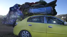 Seorang wanita pengungsi Suriah duduk di dalam mobil, saat ia bersiap untuk pulang ke Suriah sebagai bagian dari kepulangan sukarela, di kota Arsal, perbatasan timur Lebanon, Selasa (14/5/2024).  (AP Photo/Hussein Malla)