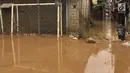 Aktivitas warga di lapangan futsal di kawasan Rawajati, Jakarta, Selasa (6/2). Banjir yang merendam kawasan tersebut menyebabkan lumpur dan sampah mengendap di setiap sudut sehingga mengganggu aktivitas warga. (Liputan6.com/Immanuel Antonius)