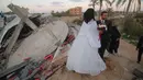 Mohammed Zourab dan pengantin perempuannya menggelar pernikahan di atas reruntuhan rumahnya di Kota Khan Younis, Jalur Gaza, 1 Maret 2020. Upacara pernikahan warga Palestina digelar di atas reruntuhan salah satu rumah yang hancur tiga bulan lalu akibat serangan jet Israel. (Xinhua/Khaled Omar)