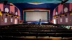 Pekerja melakukan perawatan dan pemeliharaan di aula bioskop sebagai persiapan kemungkinan pembukaan kembali setelah pelonggaran pembatasan Covid-19, di Chennai, Sabtu (3/10/2020). Jumlah kematian di India akibat virus corona meningkat melewati 100.000 pada Sabtu, 3 Oktober 2020. (Arun SANKAR/AFP)