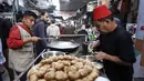 Meski berada dalam kondisi sulit dan harga barang yang melonjak tinggi, Pasar Al-Zawiya tetap ramai dikunjungi. Tampak dalam foto, pedagang kaki lima Palestina membuat falafel di pasar Zawiya Kota Gaza pada Rabu 18 Februari 2026. (Omar AL-QATTAA/AFP)