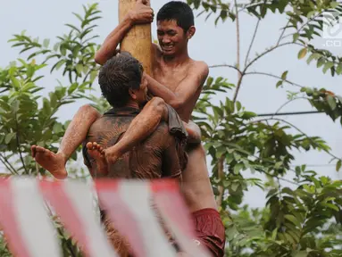 Para peserta berjibaku lumpur dan oli mengikuti lomba panjat pinang di Perumahan Griya Pamulang 2, Tangerang Selatan, Jumat (17/8). Lomba yang diselengarakan oleh Bina Remaja ini dalam rangka memeriahkan HUT Ke-73 RI. (Merdeka.com/Dwi narwoko)