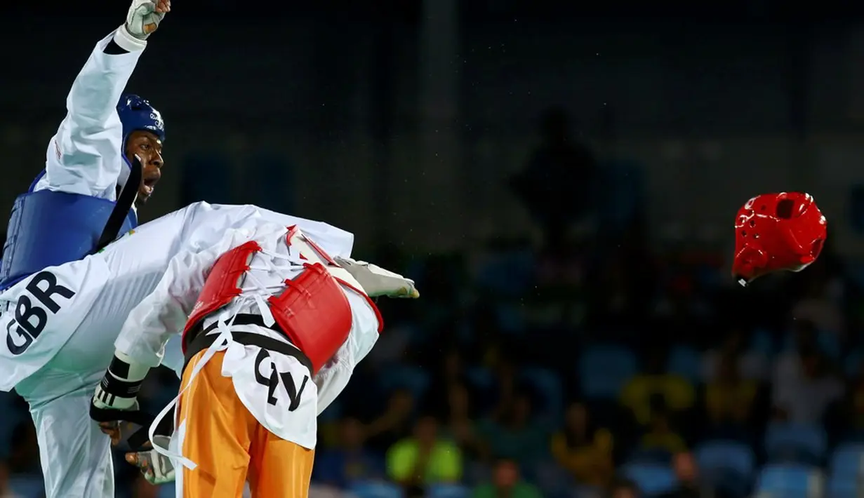  Helm taekwondoin Pantai Gading, Cheikh Sallah Cisse, terlepas setelah terkena tendangan atlet Inggris Raya, Lutalo Muhammad (kiri), dalam final kelas -80kg Olimpiade Rio 2016 di Rio de Janeiro, Brasil, (19/8/2016). (Reuters/Peter Cziborra)