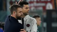 Tampak pelatih AS Roma, Daniele De Rossi bersama allenatore Bologna, Thiago Motta pada duel kedua tim di ajang Liga Italia 2023/2024 hari Senin (22/04/2024) malam WIB. (Filippo MONTEFORTE / AFP)