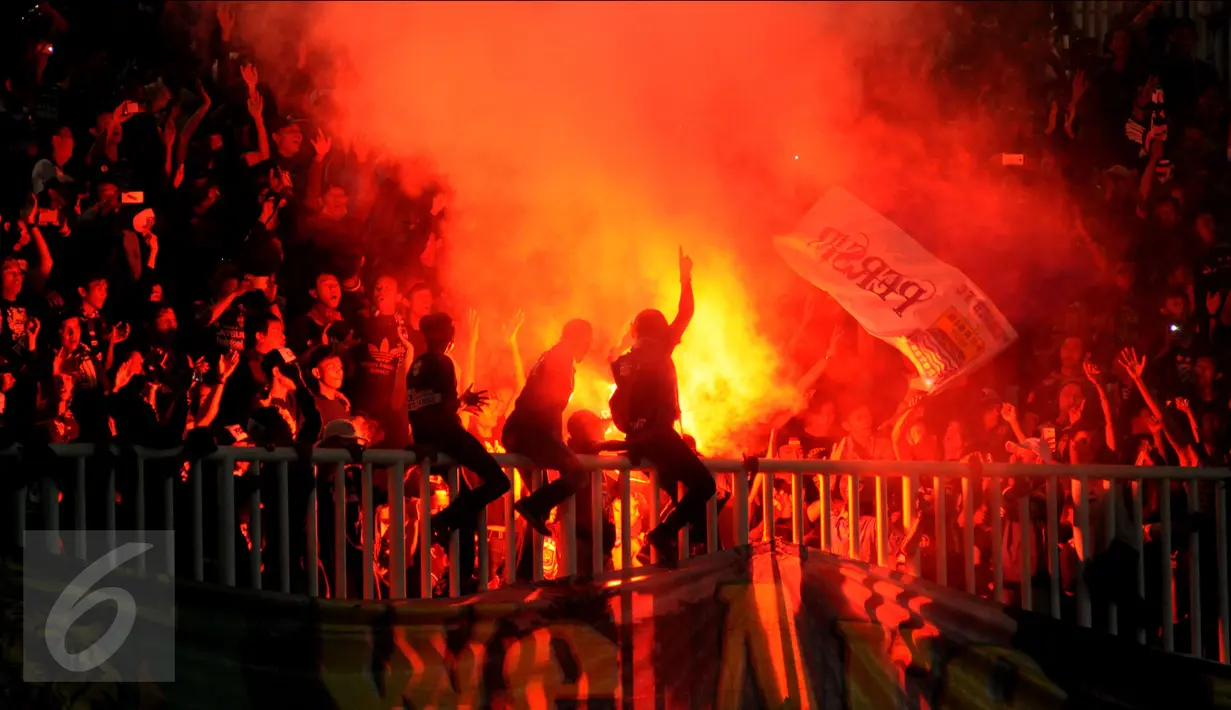 Suporter Persib menyalakan suar usai menyaksikan laga Torabika Soccer Championship presented by IM3 Ooredoo melawan PS TNI di Stadion Pakansari, Kab Bogor, Minggu (21/8). Persib menang 3-0. (Liputan6.com/Helmi Fithriansyah)