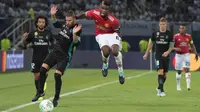 Gelandang Manchester United, Paul Pogba, berebut bola dengan bek Real Madrid, Sergio Ramos, pada laga Piala Super Eropa di Stadion Philip II, Skopje, Selasa (8/8/2017). Real Madrid menang 2-1 atas Manchester United. (AFP/Armend Nimani)