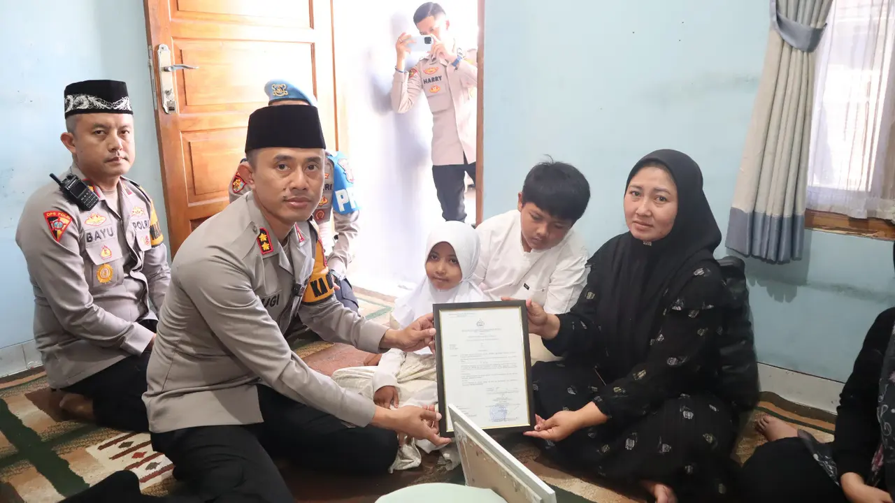 Kapolres Garut AKBP Yugi Bayu Hendarto menyerahkan SK kenaikan pangkat anumerta kepada Bripka Cecep Saeful Bahri, menjadi Aipda Anumerta, yang menjadi korban tragedi ‘Pesta Rakyat’ di Pendopo, Jumat lalu. (Liputan6.com)