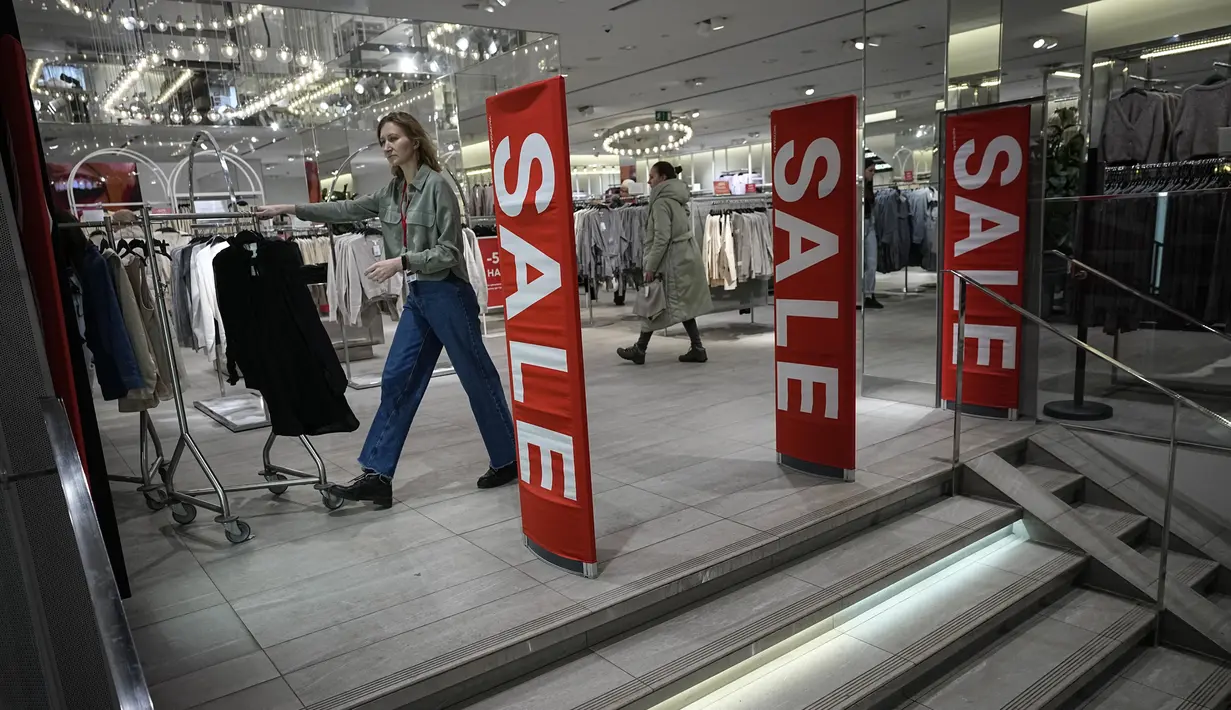 Seorang karyawan mendorong rak gantungan pakaian pada hari terakhir pembukaan toko H&M yang terakhir kalinya di Moskow, Rusia, Rabu (30/11/2022). H&M menutup seluruh tokonya sebagai bentuk protes atas serangan Rusia ke Ukraina. (AP Photo/Alexander Zemlianichenko)