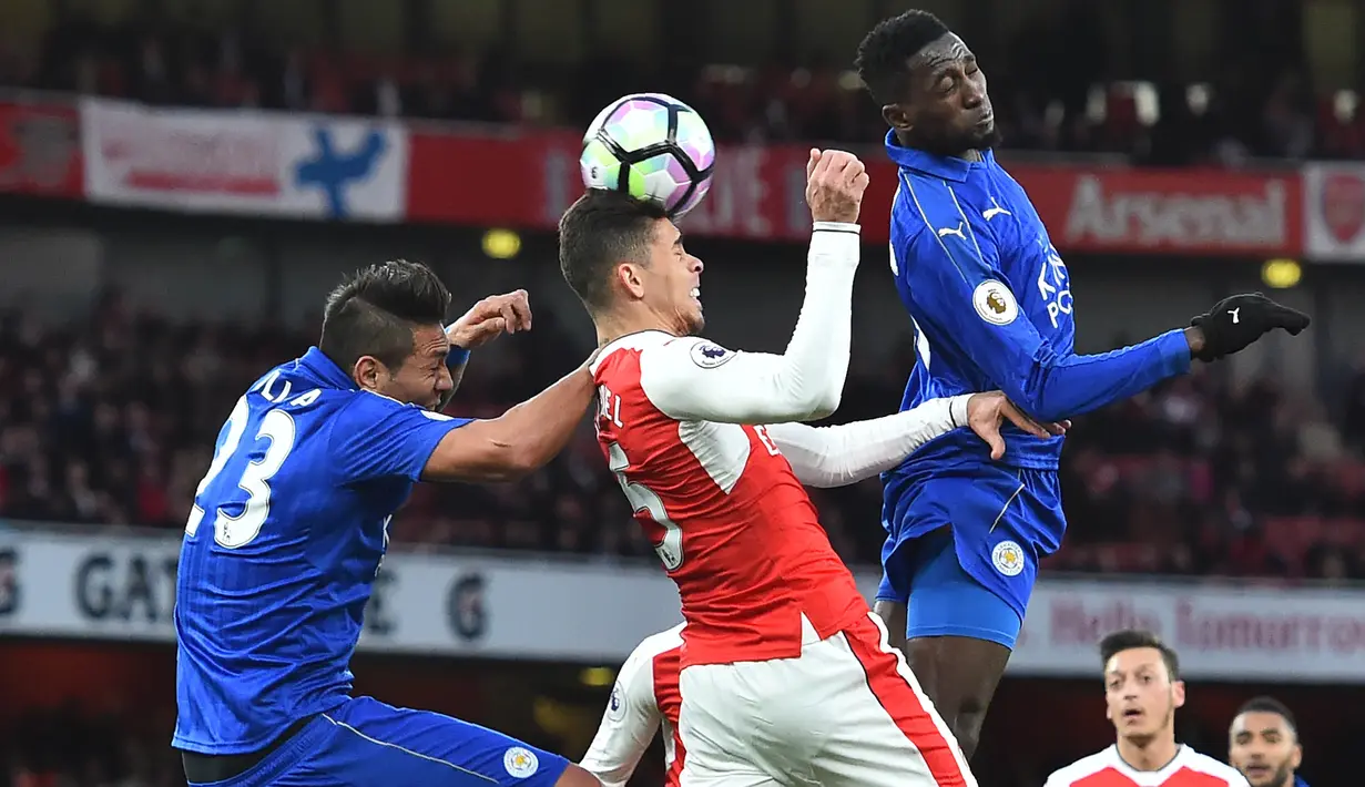 Bek Arsenal, Gabriel, membuang bola dari jangkauan pemain Leicester pada laga Premier League di Stadion Emirates, London, Rabu (26/4/2017). Arsenal menang 1-0 atas Leicester. (AFP/Glyn Kirk)