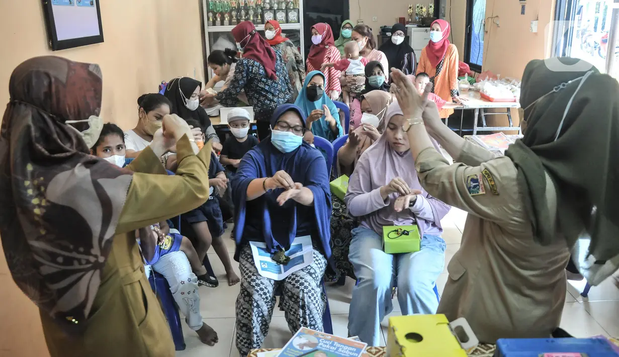 Petugas Promosi Kesehatan Puskesmas Kecamatan Menteng menunjukkan cara mencuci tangan saat sosialisasi pencegahan Hepatitis Akut di Rukun Warga 03, Kelurahan Cikini, Jakarta, Senin (23/5/2022). Sosialisasi guna mencegah penyebaran sekaligus mengimbau warga menerapkan Pola Hidup Bersih dan Sehat (PHBS) agar terhindar penyakit Hepatitis Akut yang marak menyerang anak-anak. (merdeka.com/Iqbal S Nugroho)