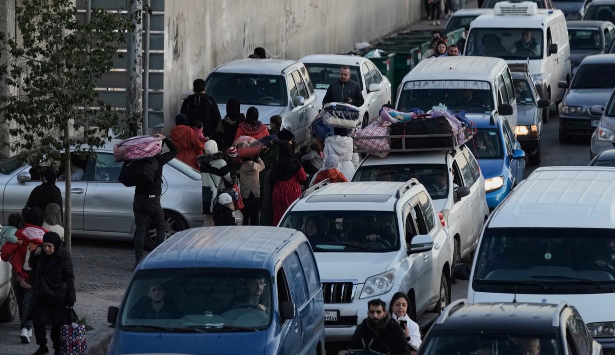 Selain serangan udara, militer Israel juga dilaporkan telah melakukan invasi darat ke Lebanon selatan pada awal pekan ini. Tampak dalam foto, mobil-mobil terjebak kemacetan di jalan raya saat warga mengungsi akibat serangan udara Israel di Dahiyeh, pinggiran selatan Beirut, Lebanon, Kamis 5 Maret 2026. (AP Photo/Bilal Hussein)
