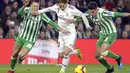 Luka Modric mencoba melewati hadangan pemain Real Betis pada laga lanjutan La Liga Spanyol yang berlangsung di stadion Benito Villamarin, Senin (14/1). Real Madrid menang 2-1 atas Real Betis. (AFP/Cristina Quicler)