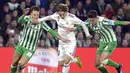 Luka Modric mencoba melewati hadangan pemain Real Betis pada laga lanjutan La Liga Spanyol yang berlangsung di stadion Benito Villamarin, Senin (14/1). Real Madrid menang 2-1 atas Real Betis. (AFP/Cristina Quicler)