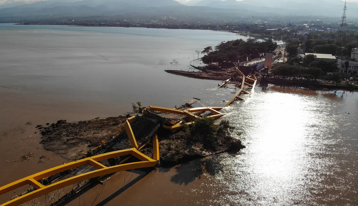 Pandangan udara memperlihatkan sebuah jembatan runtuh usai dilanda gempa dan tsunami Palu, Sulawesi Tengah, Senin (1/10). Jumlah korban tewas akibat gempa dan tsunami Palu dan Donggala menjadi 832. (JEWEL SAMAD/AFP)