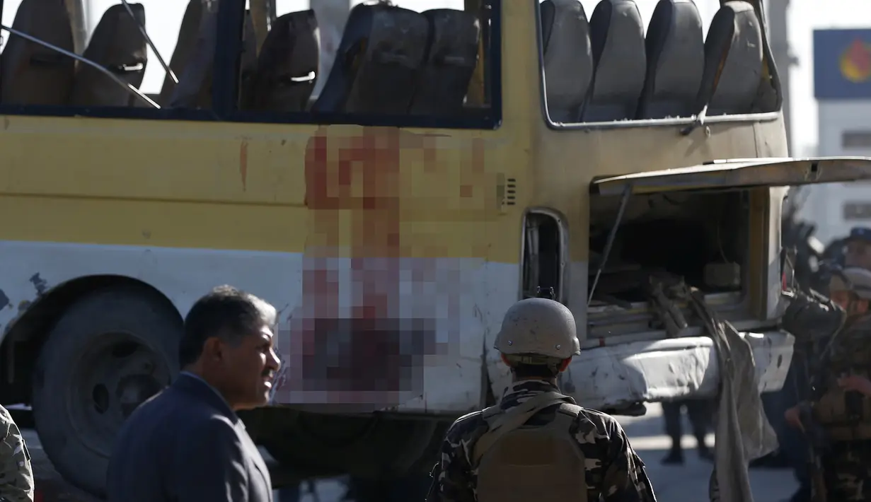  Mobil minibus yang terkena serangan bunuh diri di evakuasi petugas, Kabul, Afghanistan, Senin (20/6). Sebanyak 14 orang tewas akibat serangan ini. (REUTERS / Omar Sobhani)