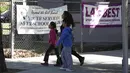 Warga melewati depan Elysian Heights Elementary School, Los Angeles, Selasa (15/12). Otoritas Los Angeles, memerintahkan penutupan sekolah menyusul adanya ancaman yang menyasar sistem pendidikan dan seluruh siswa sebanyak 640.000. (REUTERS/Jason Redmond)