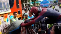 Spiderman saat membagikan sarung dengan cara mengalungkan kepada warga penerima di Solo, Senin (3/6).(Liputan6.com/Fajar Abrori)