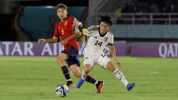Pemain Timnas Spanyol U-17, Pau Prim (kiri) berebut bola dengan pemain Jepang U-17, Gaku Nawata dalam pertandingan babak 16 Besar Piala Dunia U-17 di Stadion Manahan, Solo, Senin (20/11/2023). (Bola.com/Arief Bagus)
