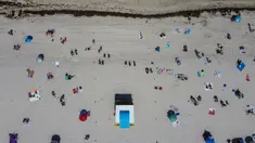 Pandangan udara menunjukkan orang-orang berada di atas pasir Miami Beach di Florida, Rabu (10/6/2020). Pantai Miami dibuka hari ini untuk pertama kalinya setelah hampir tiga bulan ditutup guna menekan jumlah penyebaran corona Covid-19. (CHANDAN KHANNA / AFP)