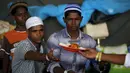 Para pengungsi etnis Rohingya saat menerima makanan di tempat penampungan, Kuala Langsa, Aceh (25/5/2015). Pemerinta RI mengalokasikan bantuan sebesar Rp 2,3 Miliar untuk pengungsi Rohingya yang berada di Aceh. (Reuters/Darren Whiteside)