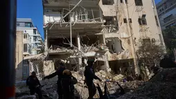 Layanan ambulans Israel melaporkan sedikitnya enam orang cedera dan kerusakan pada gedung berlantai empat setelah serangan berlangsung. Tampak dalam foto, pasukan keamanan Israel dan tim penyelamat memeriksa lokasi serangan rudal Iran di Tel Aviv, Israel, Selasa, 24 Maret 2026. (AP Photo/Oded Balilty)