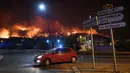 Sebuah mobil melintas saat kebakaran hutan di Les Pennes-Mirabeau, dekat Marseille, Prancis, Kamis (11/8). Penyebaran api hingga melahap habis 2.260 hektare lahan. (AFP PHOTO/BORIS HORVAT)