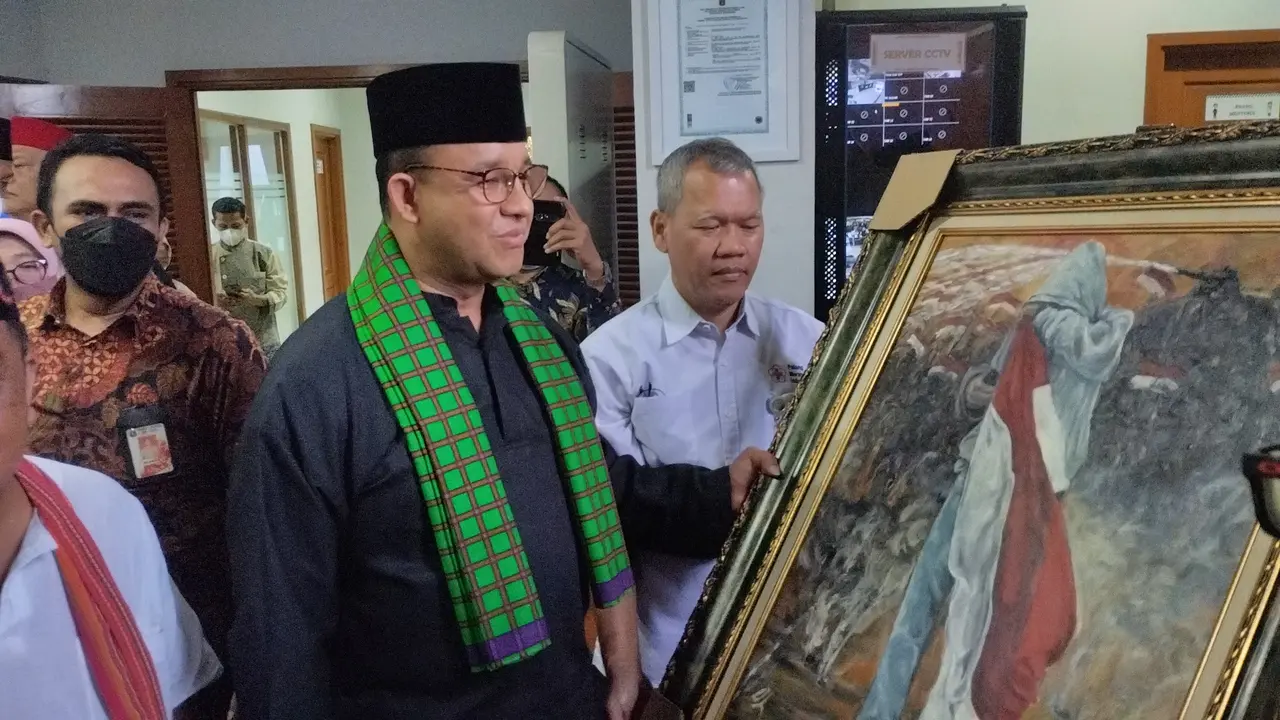 Gubernur DKI Anies Baswedan mendapat lukisan saat meresmikan penetapan nama jalan, gedung, dan zona di Jakarta dengan nama tokoh-tokoh Betawi. (Liputan6.com/Winda Nelfira)