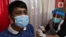 Seorang warga mendapatkan vaksin COVID-19 di Kampung Tangguh Jaya Cideng, Jakarta, Sabtu (10/4/2021). Adapun sasaran program vaksinasi massal ini kaum lanjut usia (lansia) dan pelayan publik yang sering berinteraksi dengan masyarakat. (Liputan6.com/Herman Zakharia)