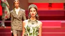 Seorang model berpose di atas catwalk dengan membawa tas besar mirip tas pasar dan mengisinya dengan sayuran untuk koleksi Dolce & Gabbana Spring/Summer 2018 di Milan Fashion Week, Minggu (24/9). (AFP PHOTO / Andreas SOLARO)