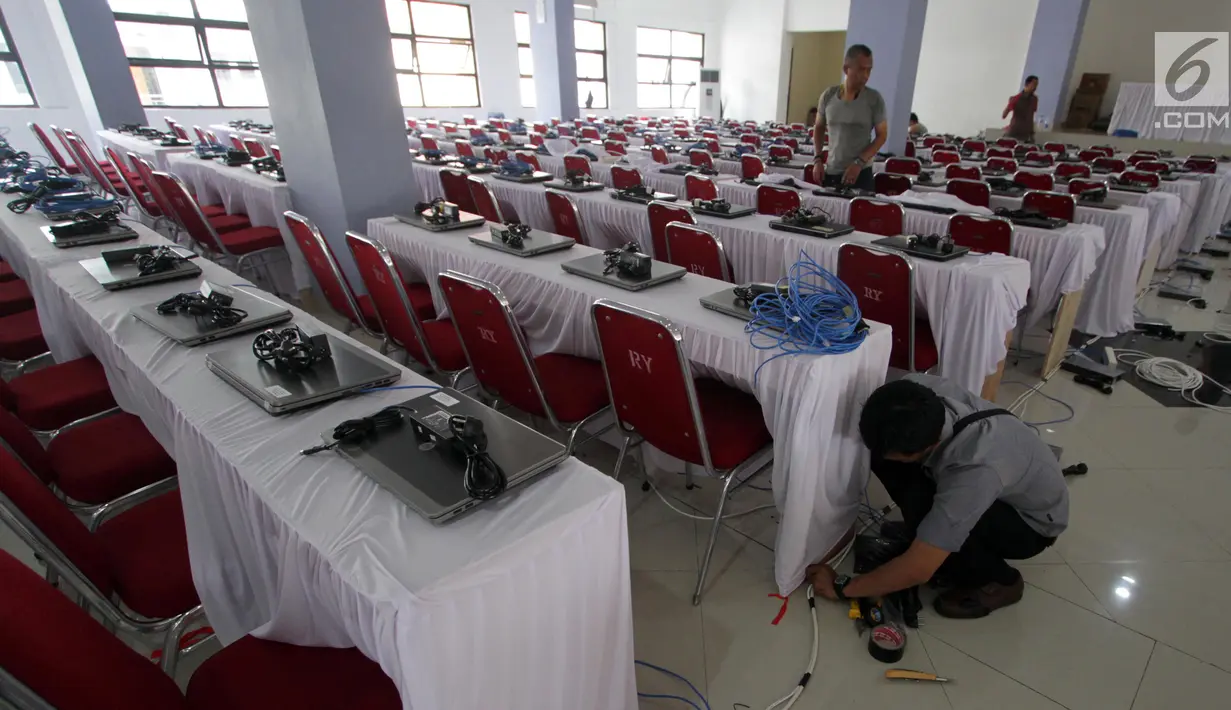 Teknisi menginstal laptop untuk tes calon pegawai negeri sipil (CPNS) di GOR Kelapa Gading, Jakarta Utara, Jumat (26/10). Tempat ini akan menjadi lokasi tes CPNS yang akan dilangsungkan pada Sabtu, 26 Oktober 2018. (Liputan6.com/JohanTallo)