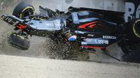 Pebalap McLaren Honda asal Spanyol, Fernando Alonso, mengalami kecelakaan setelah menabrak pebalap Haas F1, Esteban Gutierrez, dan tembok pembatas dalam F1 GP Australia di Sirkuit Albert Park, Minggu (20/3/2016). (AFP/Newspix/Alex Coppel)