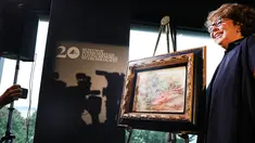 Cucu pewaris terakhir, Sylvie Sulitzer berpose dengan lukiskan karya Renoir yang dikembalikan dalam upacara di New York, Rabu (12/9). "Deux Femmes Dans Un Jardin" yang dilukis pada 1919 dicuri Nazi dari brankas Bank Paris pada 1941. (SPENCER PLATT/AFP)
