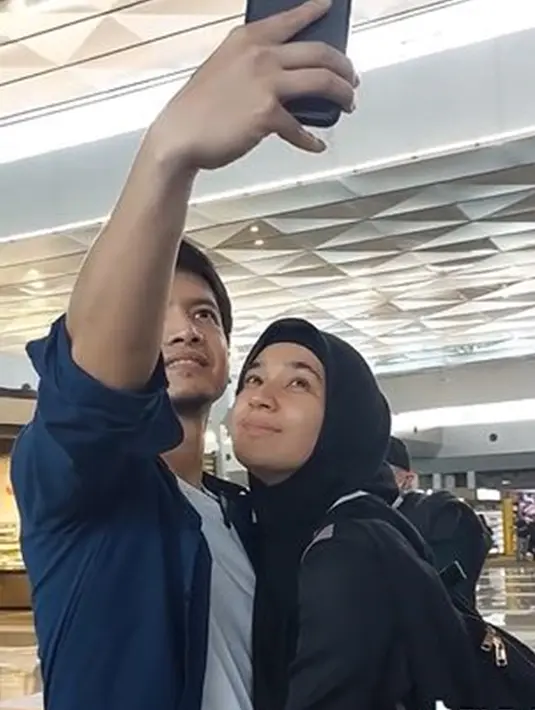 Tidak lupa, Dimas Seto juga mengajak istrinya untuk selfie sebelum LDR-an. Dhini juga mengucapkan pesan kepada sang suami untuk selalu minum vitamin yang sudah ia persiapkan sebelum pergi umrah. Dalam momen tersebut, Dhini juga sempat menangis di pelukan Dimas saat akan segera naik pesawat. (Liputan6.com/TikTok/@dimassetoofficial)