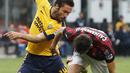 Pemain AC Milan, Hakan Calhanoglu (kanan) berebut bola dengan pemain Hellas Verona, Franco Zuculini pada lanjutan Serie A di San Siro stadium, Milan, (5/5/2018). AC Milan menang telak 4-1. (AP/Antonio Calanni)