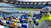 Petugas kesehatan melakukan pencegahan virus corona dengan melakukan sterilisasi di Stadion San Paolo. (AFP)