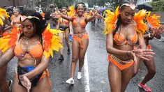 Penari karnaval menari di tengah hujan selama parade hari pertama Karnaval Notting Hill di London barat, Minggu (26/8). Karnaval Notting Hill yang merupakan pawai jalanan terbesar di Eropa diadakan setiap tahun sejak tahun 1966. (AFP/Daniel LEAL-OLIVAS)