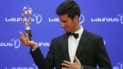 Novak Djokovic  berfoto dengan trofi yang diraihnya pada ajang penghargaan Laureus World Sports Awards 2016, Berlin, Germany, (18/4/2016).  Djokovic terpilih sebagai Laureus World Sportsman of the Year. (REUTERS/Hannibal Hanschke)