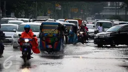 Pengendara motor melewati genangan air di kawasan Jalan Merdeka Timur, Jakarta, Selasa (1/11). Hujan deras disertai angin yang mengguyur wilayah Jakarta, mengakibatkan genangan di sejumlah ruas jalan. (Liputan6.com/Faizal Fanani)