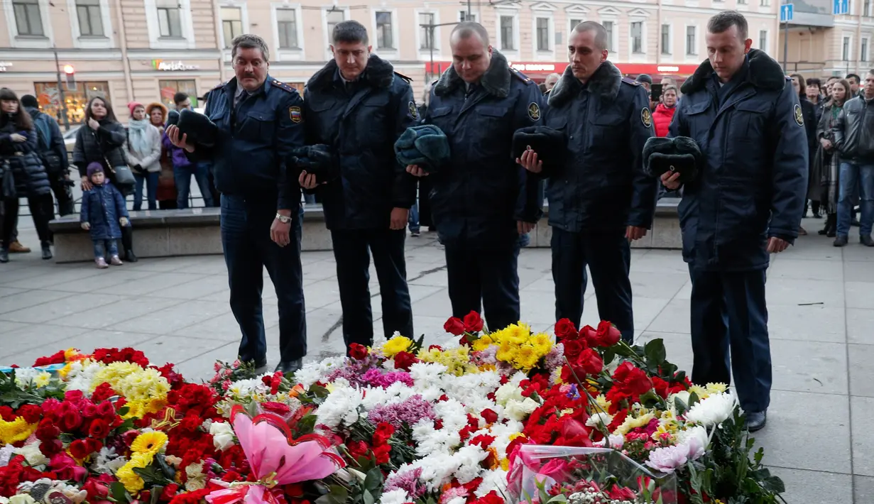 Sejumlah petugas melakukan bela sungkawa atas tragedi bom yang meledak di stasiun kereta bawah tanah St. Petersburg, Rusia, Selasa (4/4). Dikabarkan 10 orang meninggal dalam tragedi tersebut. (AP Photo / Dmitri Lovetsky)