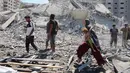 Kantor Media Pemerintah Gaza melaporkan agresi Israel yang kini memasuki hari ke-730 sejak dimulainya perang pada 7 Oktober 2023 telah menyebabkan lebih dari 67.000 warga Palestina gugur dan ratusan ribu lainnya luka-luka. Sementara itu, 90 persen wilayah Gaza nyaris rata dengan tanah akibat serangan udara dan darat Israel. Tampak dalam foto, seorang perempuan Palestina menggendong seorang anak sambil berjalan di antara reruntuhan dekat Menara Tiba yang runtuh beberapa saat setelah serangan Israel menargetkan gedung tinggi tersebut di Kota Gaza pada 10 September 2025. (Omar AL-QATTAA/AFP)
