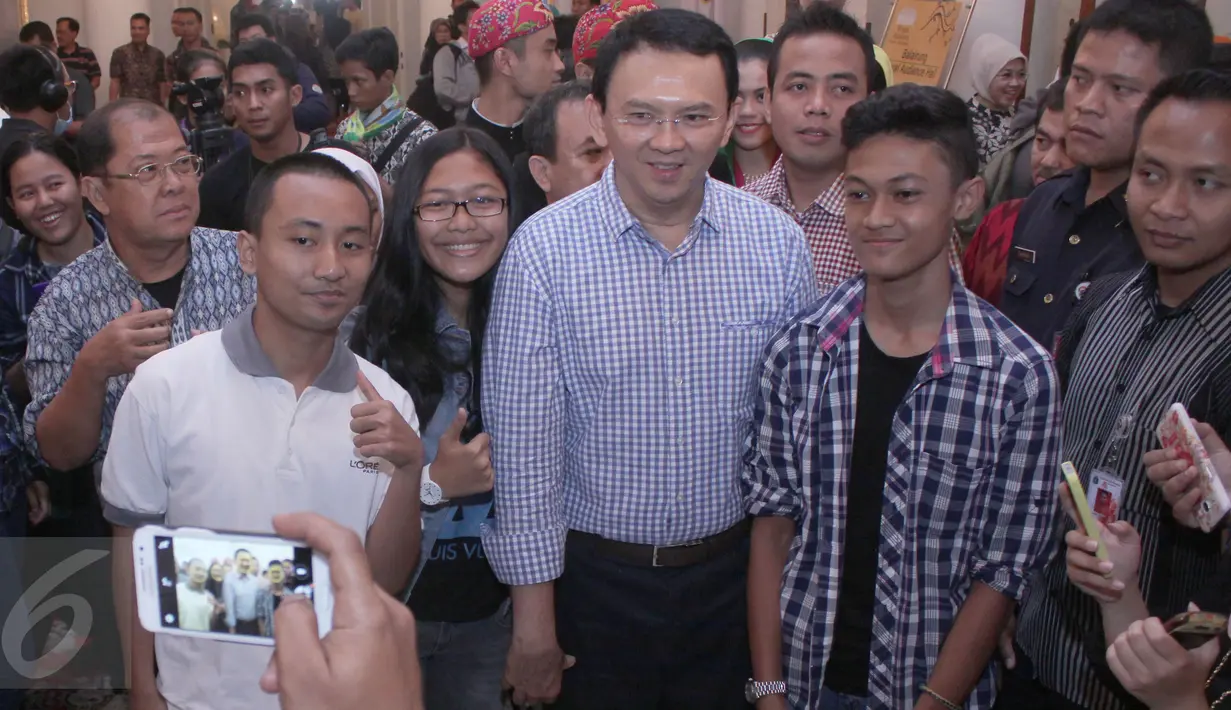 Gubernur DKI Basuki Tjahja Purnama (Ahok) berfoto bersama warga usai membuka wisata Balaikota, Sabtu (12/9/2015). Wisata Balaikota dibuka rutin Sabtu dan Minggu setiap pukul 09.00-20.00 WIB untuk objek bagian luar gedung. ‎(Liputan6.com/Angga Yuniar)