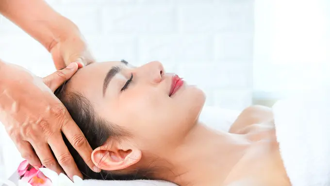 Seorang perempuan sedang melakukan perawatan pijat kepala (Foto Dok: Freepik/jcomp)