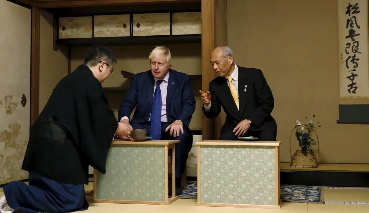 Walikota London Boris Johnson (tengah) dan Gubernur Tokyo Yoichi Masuzoe (kanan) ditawarkan secangkir teh dalam upacara minum teh, Tokyo, Rabu (14/10/2015). Johnson di jepang untuk menjalin kerja sama di bidang perdagangan dan budaya. (REUTERS/Issei Kato)