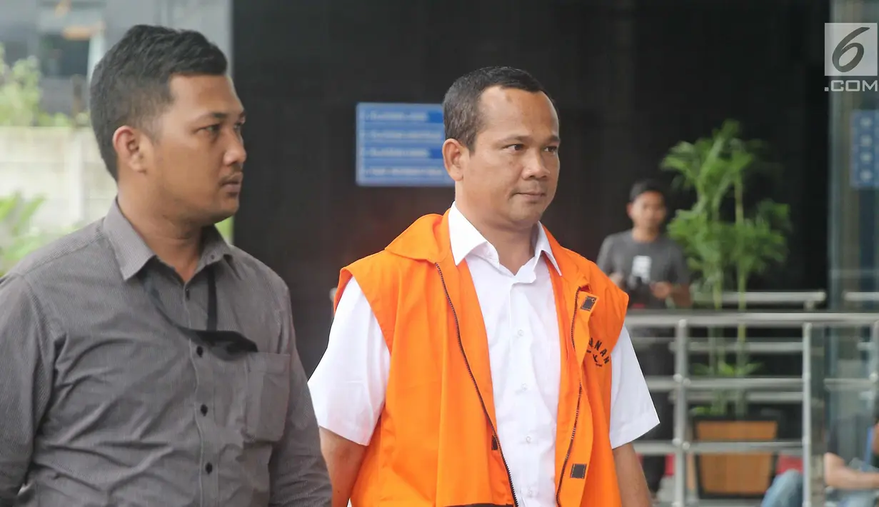 Ekspresi J Natalis Sinaga saat tiba di gedung KPK, Jakarta, Selasa (6/3). Natalis menjalani pemeriksaan lanjutan terkait dugaan transaksi suap pinjaman daerah pada APBD Lampung Tengah tahun 2018. (Liputan6.com/Herman Zakharia)