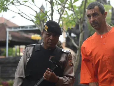 Warga negara Prancis Samuel Pierre Danguny dikawal oleh polisi sebelum konferensi pers di kantor polisi di Denpasar, Bali (18/3). Danguny ditangkap pada 15 Maret dengan kepemilikan 33 gram ganja dan 2 paket Hasis 16 gram. (AFP Photo/Sonny Tumbelaka)